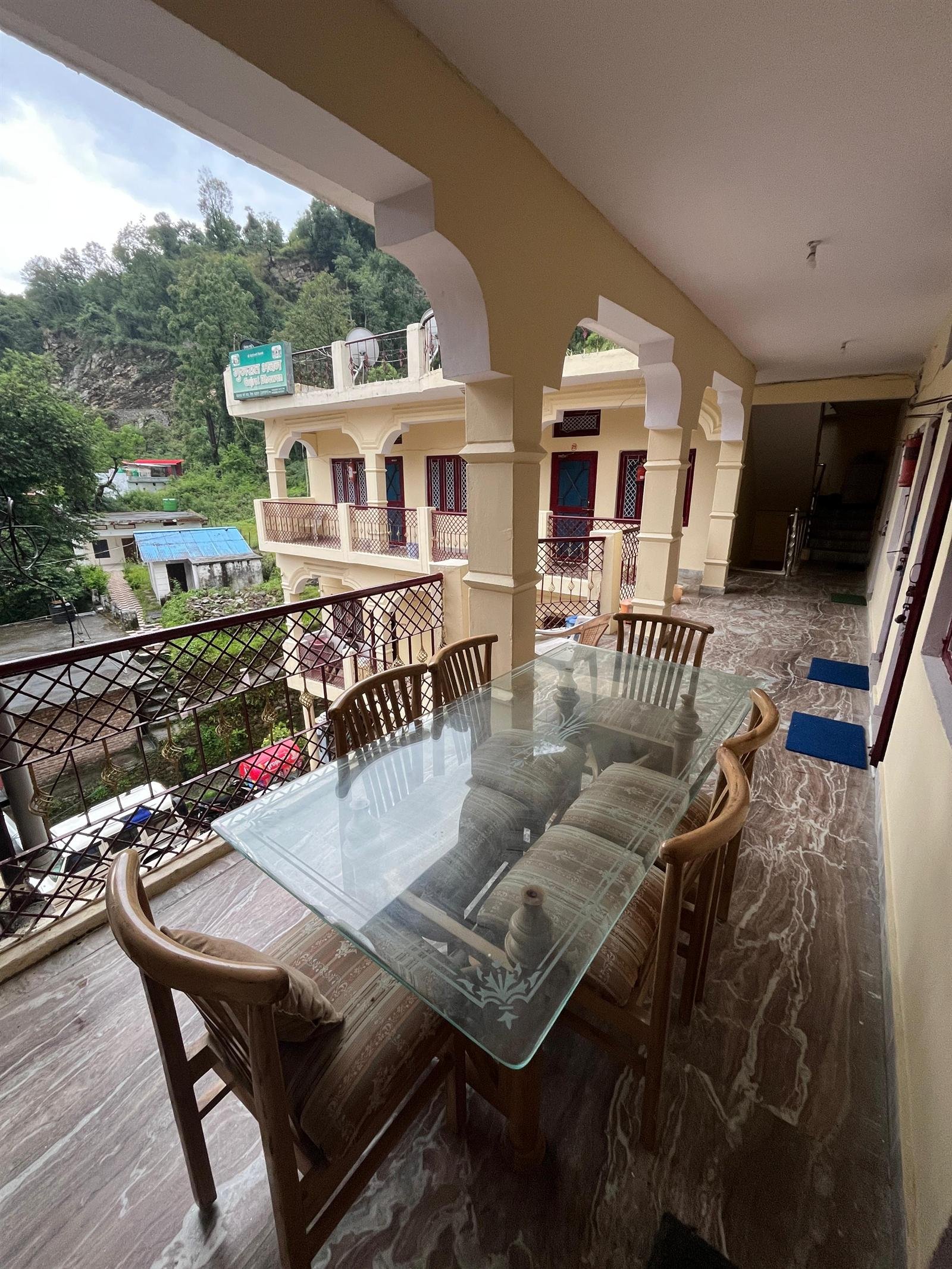 Arched veranda with seating overlooking the Himalayan hills